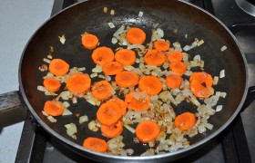 В сковороде, разогретой с маслом на среднем огне,  пассеруем  5-6 минут нашинкованный лук. Добавляем тоненькие кружки моркови (можно натереть) и подержим на огне еще минут 5-6, помешивая время от времени. 