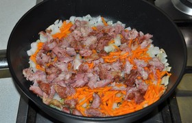 Кусочки кладем в сковороду, добавляем и натертую морковь. Продолжаем обжаривать и помешивать еще 3-4 минуты.