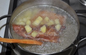 В кипящий бульон закладываем нарезанную картошку, пусть варится вместе с ребрышками.