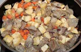 Кладем репу и морковь, а через 3-4 минуты заливаем мясо с овощами сидром (или яблочным соком). Забурлило-закипело – накрываем крышкой, огонь – на слабый, пусть мясо тушится полчаса.