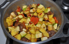 Нарезаем кубиком все овощи. И когда мясо почти готово – добавляем картошку, кабачки и баклажаны. Приправляем перцем и солью. 