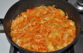 Добавляем тертую морковь, посыпаем паприкой, кладем 60-70 г сливочного масла и продолжаем пассеровать еще 8-9 минут. Перекладываем в тарелку.