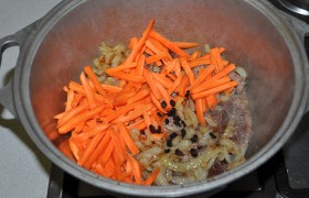 К обжаренному мясу добавляем морковь и лук. Всыпаем зиру, барбарис и кориандр. Помешиваем, пока - все на том же сильном огне - обжарится морковь.