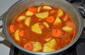 В соус засыпаем нарезанные картошку и морковку, приправляем солью и перцем, накрываем, тушим до готовности картофеля 20-25 минут.