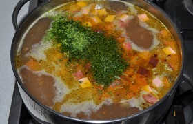 Спустя 4-5 минут сыплем в суп зелень, перемешиваем, накрываем, выключаем конфорку. Даем супу настояться 5-10 минут.
