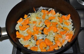 Ставим разогреваться сковороду с 2-3 ложками масла на средний огонь, шинкуем лук и морковь. Засыпаем и, периодически помешивая,  пассеруем  овощи 7-9 минут, до мягкости.