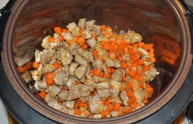Пока мы маленькими кубиками шинкуем морковь и лук, мультиварка стоит на разогреве. Включив режим жарки, 10 минут обжариваем, помешивая, свинину. Добавляем лук с морковью и жарим еще 5 минут.