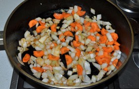 Для  заправки  в сковороде, снизив огонь до среднего, 6-7 минут пассеруем вместе порубленные луковицу и морковь. 