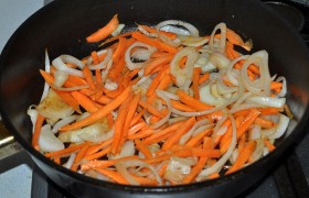 Засыпаем лук и морковь, 2-3 минуты при постоянном перемешивании обжариваем,