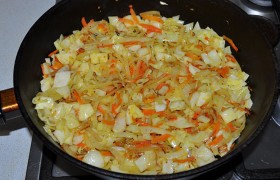 Шинкуем капусту, полукольцами - лук и натираем крупно морковь. На среднем огне с растительным маслом  пассеруем  7-8 минут лук с морковью, добавляем в сковородку капусту, солим, перчим и, немного прибавив огонь, жарим еще 8-9 минут, не забывая помешивать. Остается натереть в начинку яйца. 