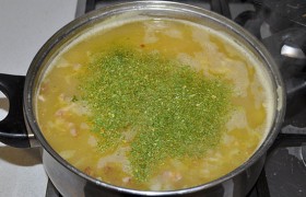 Через 2-3 минуты посыпаем суп зелень, снова закрываем кастрюлю и выключаем. Даем супу настояться 10 минут.