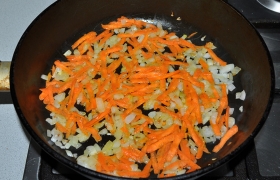 Чтобы не опоздать с  заправкой , с нее и начинаем. Ставим сковороду с маслом, пока разогревается на среднем огне, шинкуем лук, закладываем,  пассеруем  5-6 минут. Добавляем морковь, продолжаем еще 3-4 минуты.