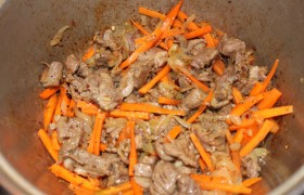 добавляем к нему нарезанную тоненькой длинной лапшой морковь. Перемешиваем морковь с мясом и луком, тушим 10 минут.