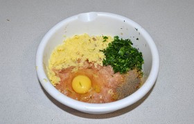 Кладем сухари (или манку), приправы, натертый картофель, яйцо, часть зелени, все вместе вымешиваем обеими руками 2-4 минуты, пока фарш станет достаточно густым. 