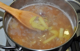 Тем временем нарезаем картофель и опускаем в кипящий бульон, бросаем горошки перца.