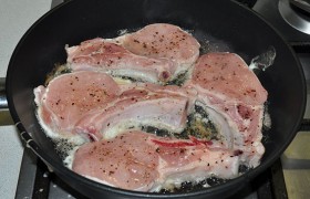 Раскладываем мясо в сковороде. Жарим корейку 4-5 минут, переворачиваем и солим.