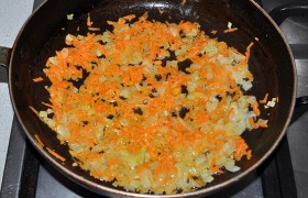 Ставим кастрюлю с водой. А вторую конфорку занимаем сковородой с маслом. Пока оно разогревается на среднем огне, шинкуем лук и натираем морковь для  заправки  супа. И 8-10 минут пассеруем овощи, периодически помешивая.