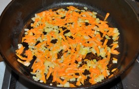 Ставим сковороду на средний огонь, хорошо разогреваем масло, кладем нашинкованный лук и морковь (которую можно просто натереть),  пассеруем  8-9 минут, порою помешивая.