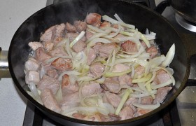 Лук добавляем к свинине, все так же помешивая, жарим еще 3-5 минут.