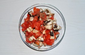 Промытые шампиньоны (другие грибы быстрой готовки) нарезаем небольшими кусочками, такими же – помидоры. Сложив в миску, посыпаем приправами, мелко порубленным чесноком, перемешиваем.