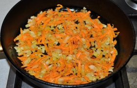 Сковороду с маслом разогреваем на сильном огне, всыпаем нашинкованный мелким кубиком лук, помешивая, обжариваем 4-5 минут. Добавляем крупно тертую морковь, обжариваем еще 3-4 минуты.