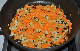 Пока на среднем огне конфорки разогревается в сковородке масло, мелко рубим лук и натираем морковку.  Пассеруем , помешивая, 8-10 минут. 