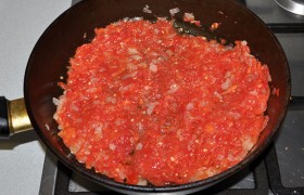 Выкладываем помидоры в сковороду с луком. Шафран растираем, разводим в полустакане горячей воды и вливаем в соус. Посыпаем сахаром (от лишней кислоты), солью, перцем, плюс паприка и зира. Тушим 8-10 минут на слабом огне.