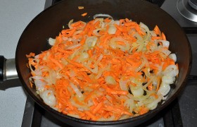 Пока на среднем огне греется в сковороде масло – нарезаем полукольцами лук и трем морковки. Овощи 5-7 минут  пассеруем , не забывая помешивать.