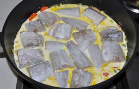 На слой овощей выкладываем кусочки рыбы, заливаем сливками, предварительно разогретыми в микроволновке или в ковшике на плите. Немного солим и перчим.