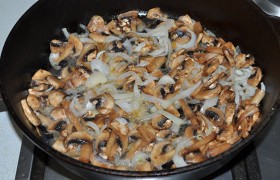 Нарезаем полукольцами оставшийся лук и 6-7 минут  пассеруем  его в сковороде на среднем огне. Кладем нарезанные грибы, держим на огне, пока выпарится жидкость (5-6 минут).