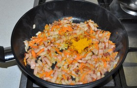 В сковороду кладем натертую морковь, посыпаем перцем, солью - и куркумой, которая придаст вкусу супа пикантную нотку. Но вы можете ее заменить своими любимыми специями. Перемешиваем и держим на огне, помешивая, еще 3-4 минуты.