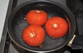 На томатах делаем крестообразные надрезы и кладем в кипящую воду.