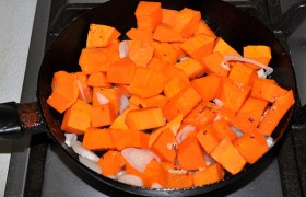 На жире, вытопленном из бекона, обжариваем кубики тыквы с луком, часто переворачивая, 8-10 минут.