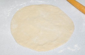 Тесто раскатываем в круг толщиной примерно 3 мм, переносим на противень для выпечки.