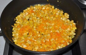 Засыпаем замороженную кукурузу, тушим 3-4 минуты. Заправку перекладываем в кастрюлю с супом, где почти сварился картофель, варим 3-5  минут.