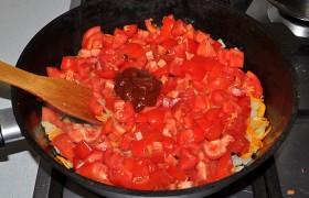 Засыпаем в сковороду мелким кубиком нарезанные помидоры, томатную пасту, сахар, приправы на свой вкус. 