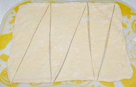 Когда тесто готово – определяем, какого размера будем печь рогалики, Раскатываем пласты до нужного размера (примерно 30 на 32 см) и толщины около 4 мм, размечаем, разрезаем на треугольники.