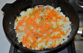 Морковку натираем (или нарезаем), добавляем к луку и продолжаем помешивать и обжаривать еще 3-4 минуты.