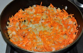 Порубленные кубиком луковицы и тертые моркови закладываем в разогретую с маслом сковороду, на огне больше среднего  пассеруем  5 минут, помешивая.