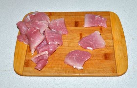 Кусок свинины нарезаем поперек мясных волокон тонкими (по 7-8 мм) и небольшими ломтиками (40-50 мм).