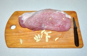Свежую охлажденную свинину после промывания самым тщательным образом обсушиваем.  Шпигуем мясо : чеснок делим на четвертинки вдоль, обмакиваем в соль и заталкиваем в отверстия, которые делаем тонким острым ножиком. 