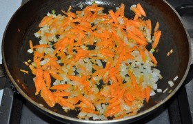 А пока готовим суповую  заправку . Сначала  пассеруем  на масле нашинкованный лук, 7-8 минут. Кладем натертую морковь и пассеруем еще 5 минут. Не забываем время от времени перемешивать. 