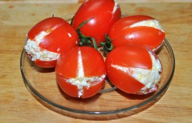 Плотно закладываем салат в помидорки, пальцами поправляем  форму, протираем салфетками. Укладываем в тарелку лук, помидоры, украшаем «листочками» из огурца (либо просто нарезаем его тонкими  слайсами ). 