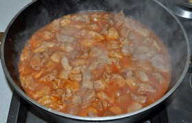 Кладем томатную пасту, вливаем горячую воду, солим. После закипания накрываем, снижаем огонь до малого, и свинина тушится 20-25 минут – до мягкости.