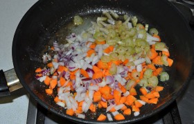 А в сковороду засыпаем нашинкованные лук и морковь, так же быстро, все время перемешивая, обжариваем 3-4 минуты.
