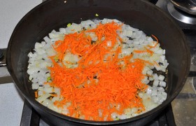 Натираем морковь, засыпаем в сковороду и вместе с луком на том же огне обжариваем еще 3-4 минуты.