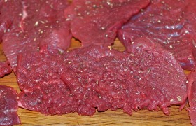 Вкладывая в пакет из пищевой пленки, чтобы избежать брызг,  отбиваем  каждый кусок мяса с обеих сторон. Посыпаем мясо солью и перцем. 
