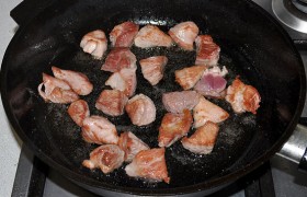 На сильном огне в сковороде  раскаляем масло . Половину мяса раскладываем, через минуту переворачиваем, еще помешиваем около минуты – и перекладываем мясо, на котором образовались корочки, в посуду для тушения. Жарим вторую половину мяса.