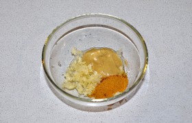 Дольки чеснока измельчаем через пресс, соединяем чеснок с готовой приправой, горчицей и маслом. Вымешиваем венчиком или вилкой, чтобы маринад стал однородным.