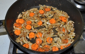 Засыпаем нарезанный полукольцами лук, после 3-4 минут обжарки добавляем морковь, жарим еще 2-3 минуты.